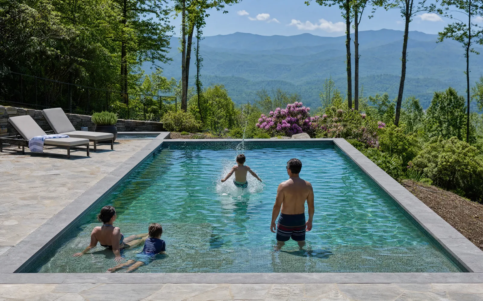 A family swimming in a pool with a mountain view