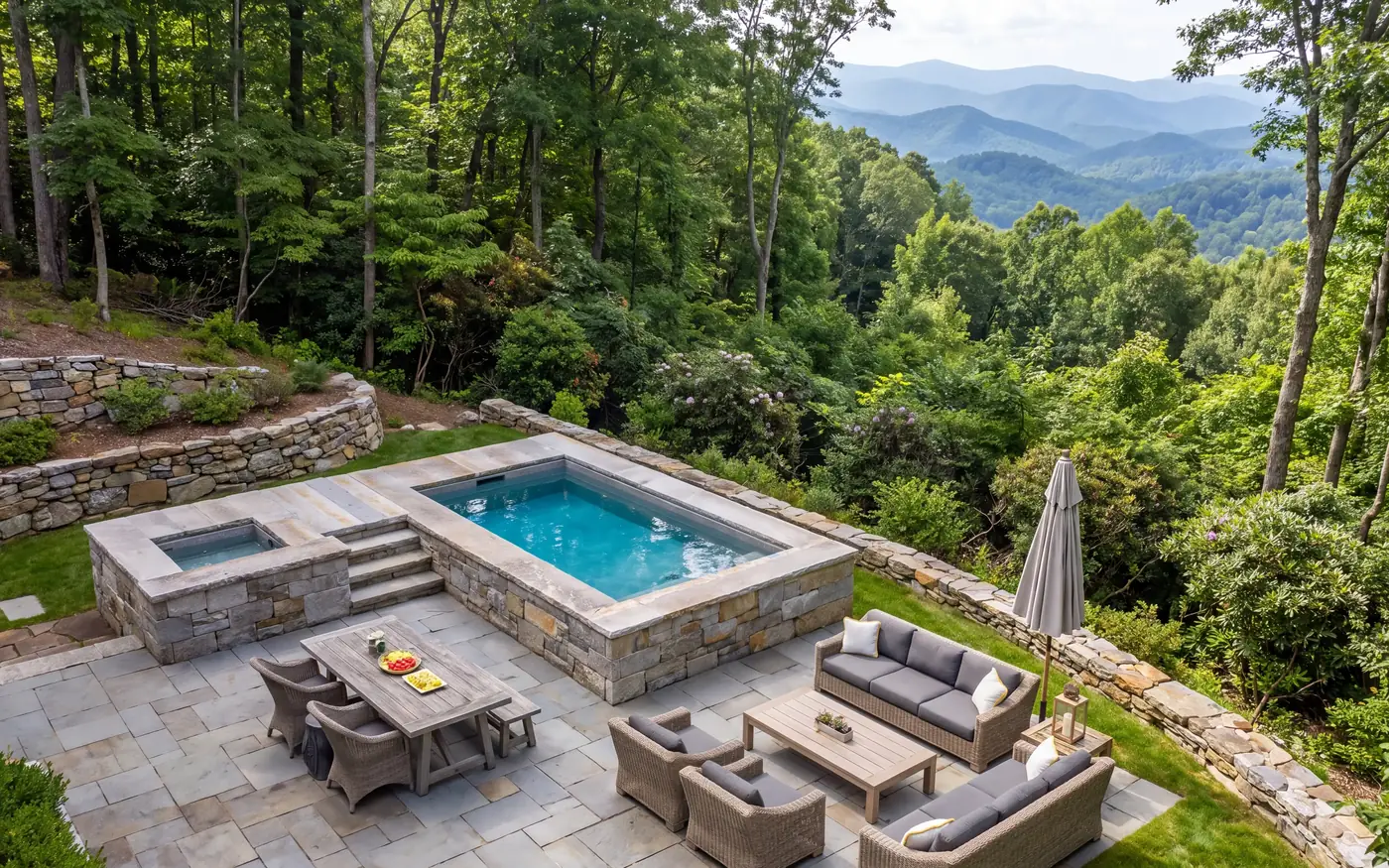 Raised pool and spa with a stone patio